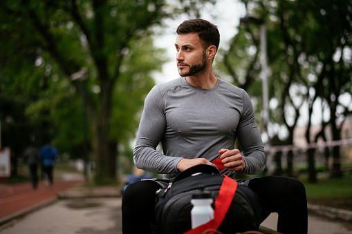 Handsome man preparing for working out. Man training outdoors.