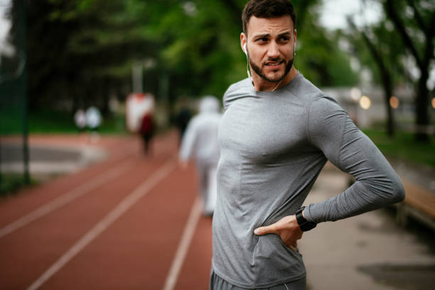 istock Sportsman feeling backache at a park 1291356025