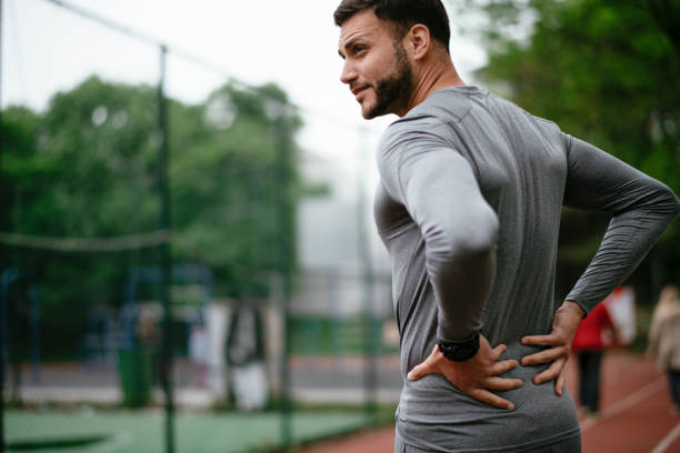 istock Sportsman feeling backache at a park 1291356519