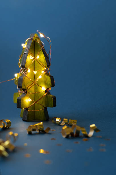 istock a wooden Christmas tree is wrapped with a garland 1291358203