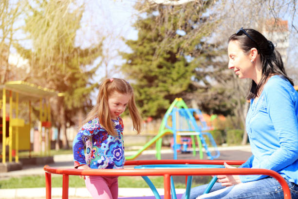 istock Mother and her daughter having fun in a playground 1291360042