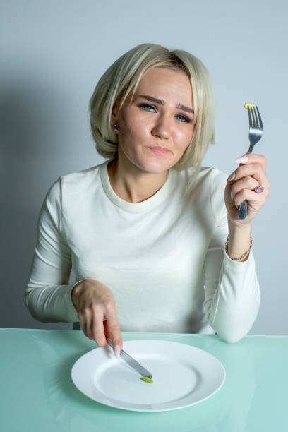 istock The girl sits at the table and eats food. 1291361429