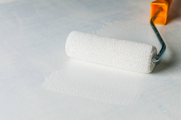 istock Painter's roller leaning against a white wooden board 1291363116