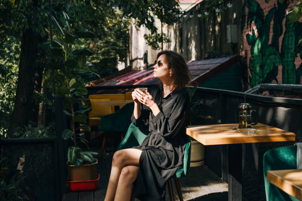 istock Young woman resting in cafe terrace and drinking tea. 1291363152