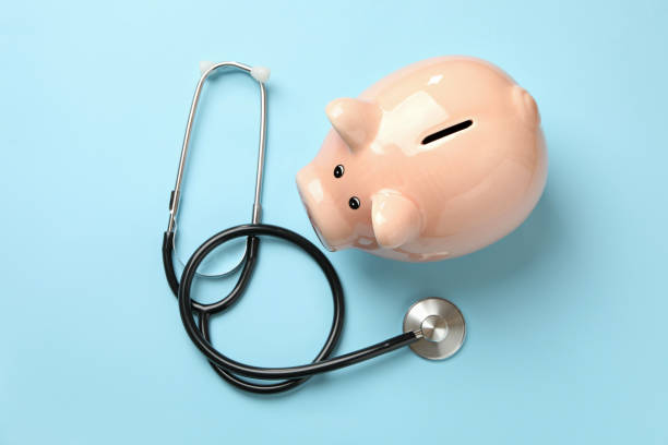 istock Stethoscope and piggy bank on blue background 1291363341
