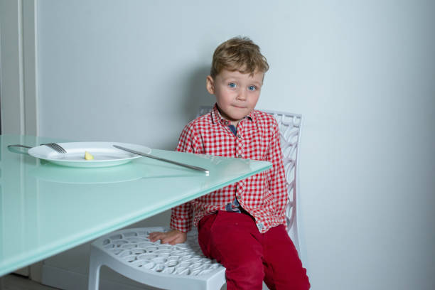 istock Boy sitting on a chair and looking at the camera. 1291363605