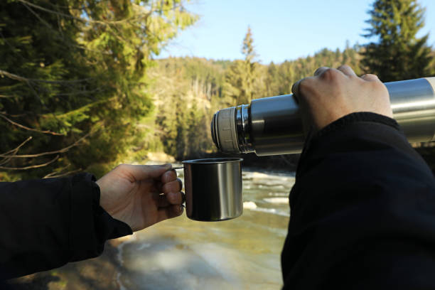 istock A man pours coffee from a thermos into a cup in forest 1291364375