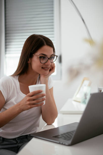 istock Businesswoman drinking coffee while working from home. 1291364597