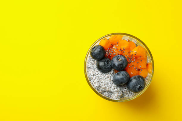 istock Glass of delicious chia pudding on yellow background 1291364769