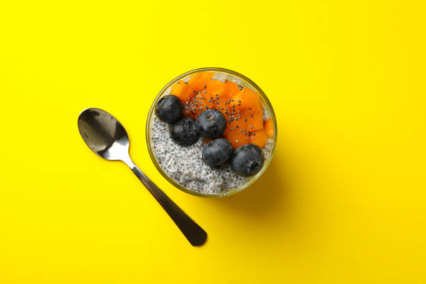 istock Glass of delicious chia pudding on yellow background 1291364781