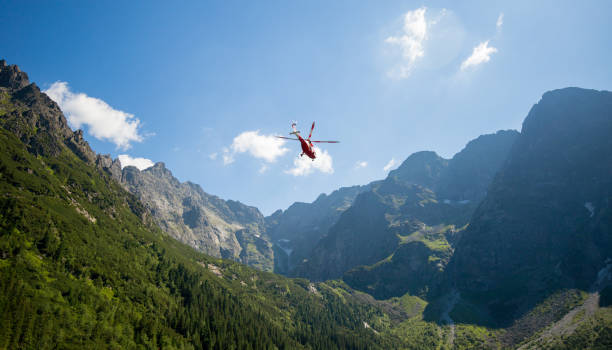 istock Red helicopter is flying between mountains peak, summer time 1291365974