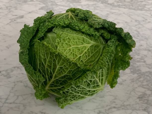 istock A curly green cabbage on a white marble plate 1291366583