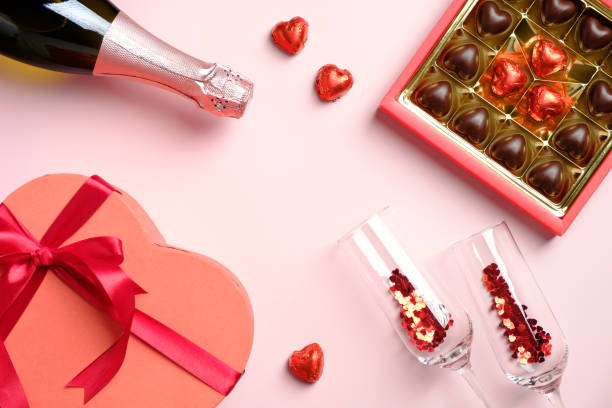 Happy Valentines Day concept. Flat lay, top view box of chocolates, champagne glasses with confetti, heart-shaped box, champagne bottle Happy Valentines Day concept. Flat lay, top view box of chocolates, champagne glasses with confetti, heart-shaped box, champagne bottle heart shape valentines day chocolate candy food stock pictures, royalty-free photos & images