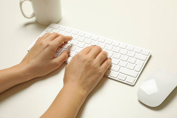 istock Woman working on modern keyboard on white background 1291368529