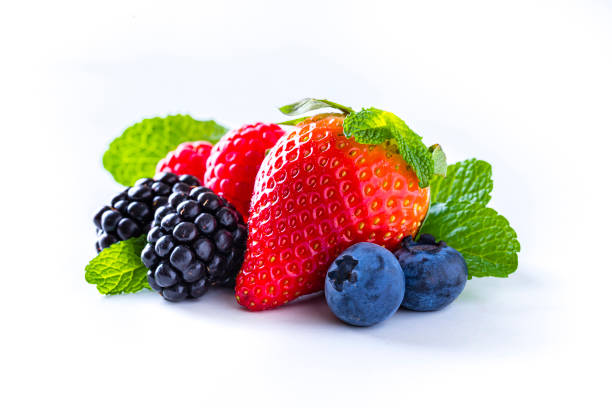 Front view of a group of mixed berries like strawberries, blueberries, blackberries and raspberries with some mint leaves isolated on white background. Studio shot taken with Canon EOS 6D Mark II and Canon EF 100 mm f/ 2.8