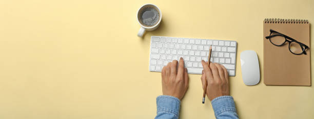 istock Woman working on modern keyboard on beige background 1291368761