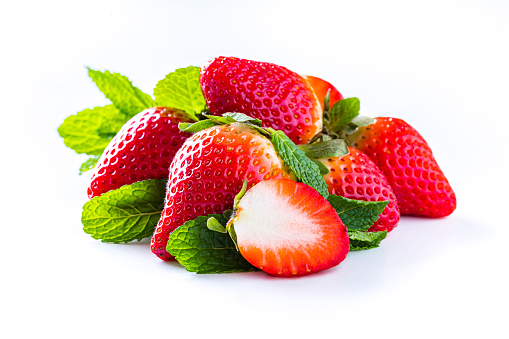 Front view of a group of strawberries with some mint leaves isolated on white background. Studio shot taken with Canon EOS 6D Mark II and Canon EF 100 mm f/ 2.8