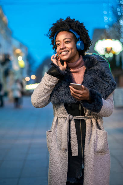 istock Young woman using smart phone at the street 1291369233