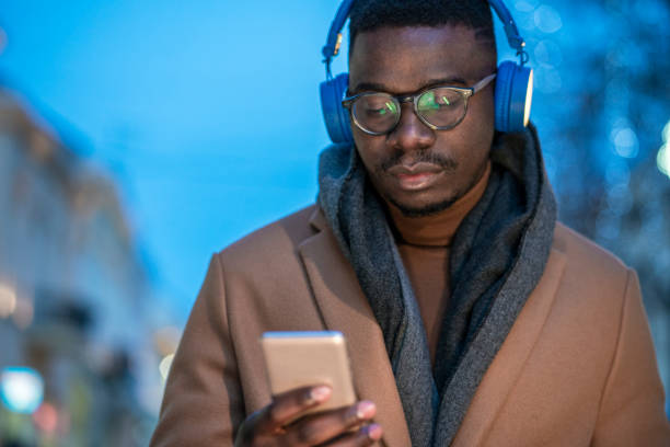 istock Young man using smart phone at the street 1291369782
