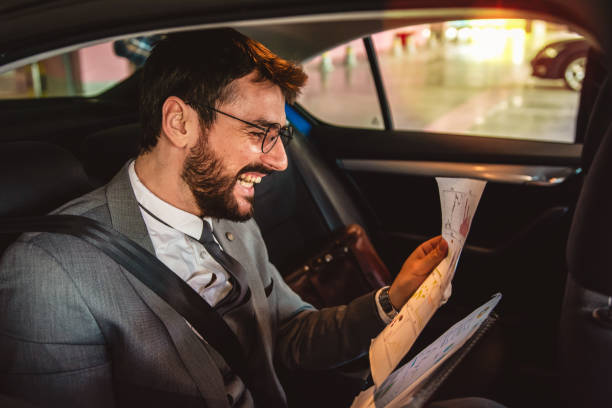 istock Businessman working in back seat of car 1291375362