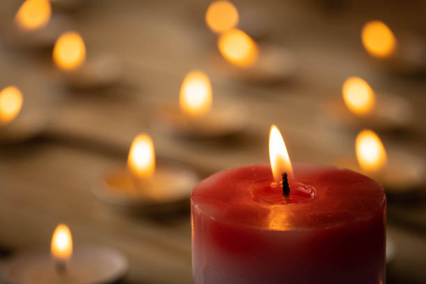 istock Candles on a wooden background. A red sick candle that changes color when you light it and small candles. Shallow depth of field. 1291376739