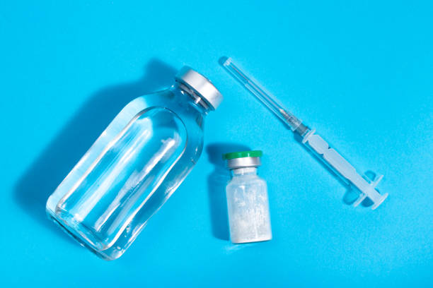istock Antibiotic kit: powder, injection solution, syringe. Breeding for intramuscular and intravenous administration. Medications to treat infectious bacterial diseases on a blue background. 1291377046