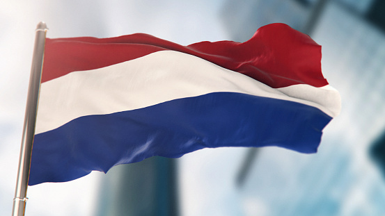 National Flag of Netherlands Against Defocused City Buildings