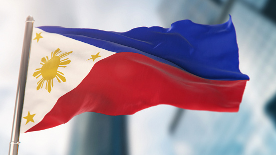 National Flag of Philippines Against Defocused City Buildings