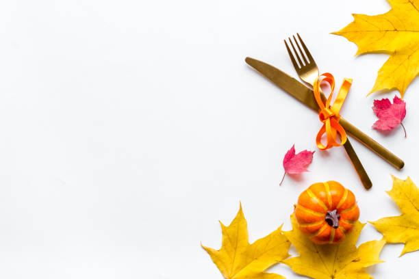 istock Thanksgiving table setting with cutlery pumpkins and autumn leaves 1291381285