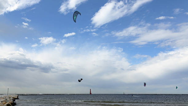 istock Kite-boarders windsurfing on a partly cloudy day 1291383046