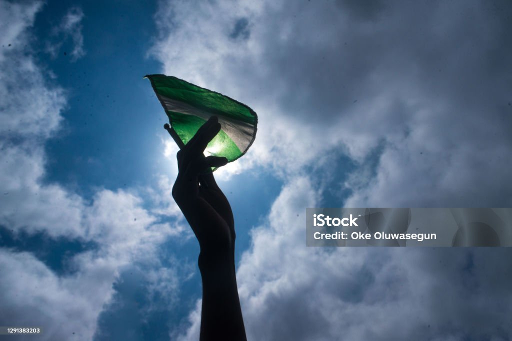 Nigeria flag A protesters raises Nigeria flag during  the EndSars protest in Nigeri. End Sars Movement Stock Photo