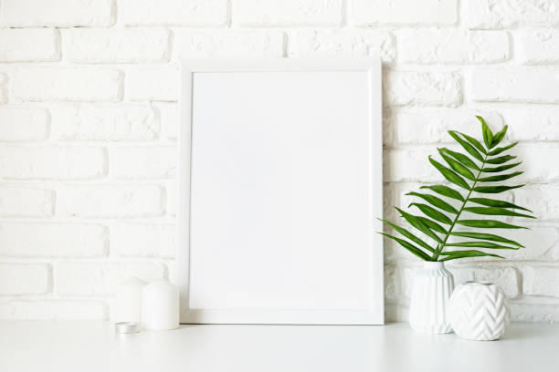 istock Poster template mock up with white vases and leaves on white brick wall background 1291384338