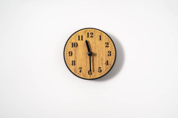 istock wood office wall clock with white dial on white background. wall clock on white background, top view. 1291388582