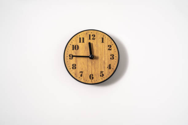 istock wood office wall clock with white dial on white background. wall clock on white background, top view. 1291388994