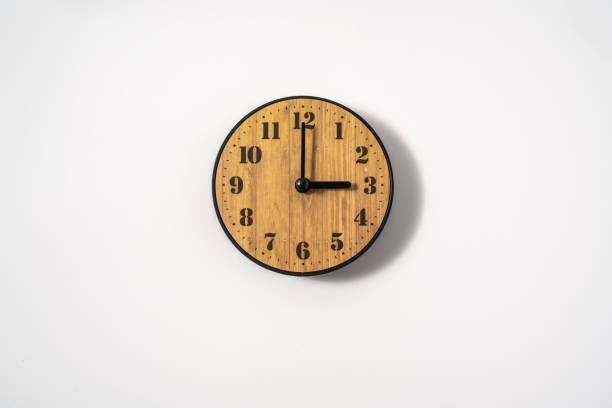 istock wood office wall clock with white dial on white background. wall clock on white background, top view. 1291389439