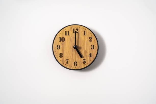 istock wood office wall clock with white dial on white background. wall clock on white background, top view. 1291390191