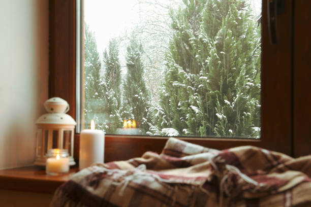 istock Plaid, candles and lantern on wooden windowsill 1291390261