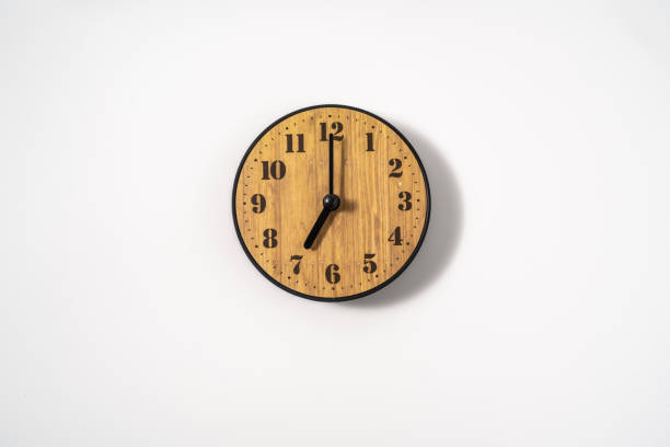 istock wood office wall clock with white dial on white background. wall clock on white background, top view. 1291390358
