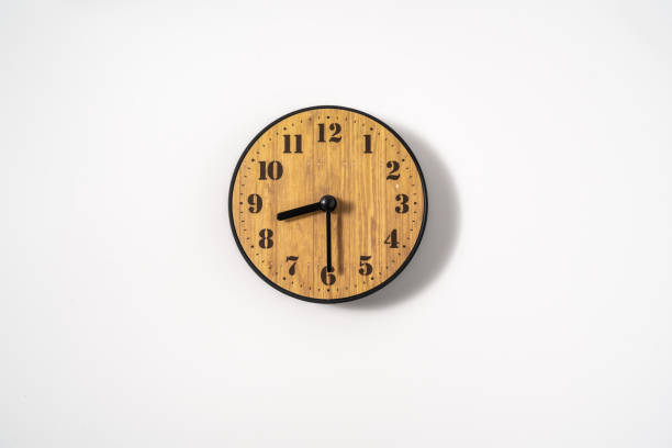 istock wood office wall clock with white dial on white background. wall clock on white background, top view. 1291390816