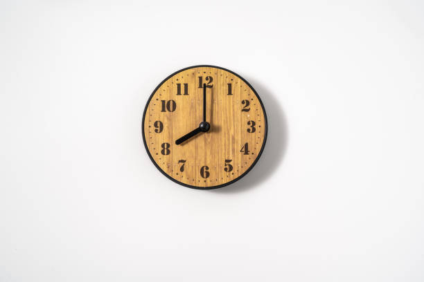 istock wood office wall clock with white dial on white background. wall clock on white background, top view. 1291390865