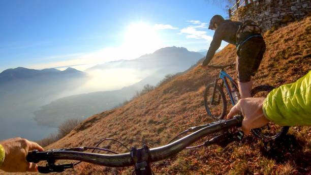 istock Mountain bikers ride across mountain ridge in the morning 1291390897