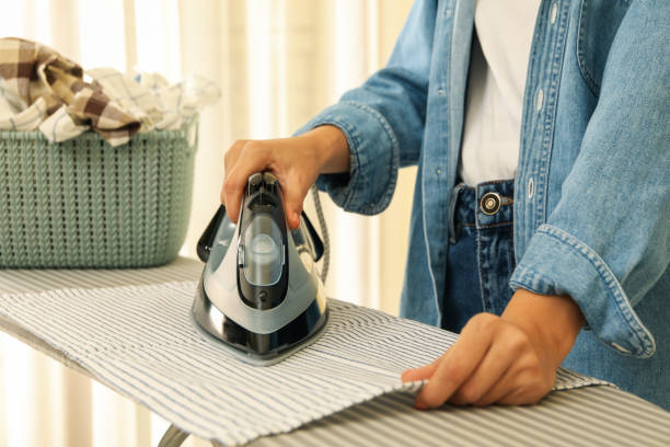 istock Woman in jeans ironing kitchen towel on ironing board 1291390921