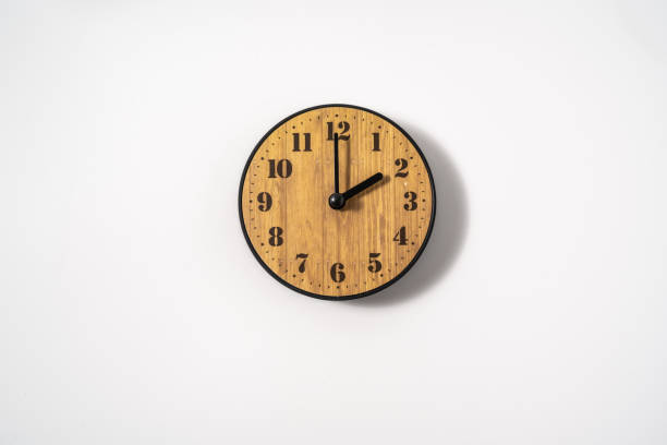 istock wood office wall clock with white dial on white background. wall clock on white background, top view. 1291392460