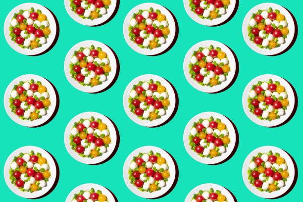 istock Fresh salad with cherry tomatoes, mozzarella cheese and microgreens. Pattern from a plate on a green background 1291394225