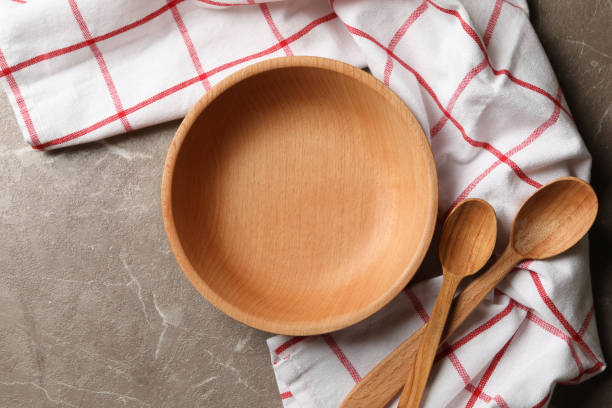 istock Kitchen napkin with wooden dishes on gray table 1291395602