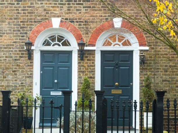 Residential Blue Doors in the City Color image depicting the exterior architecture of terraced residential houses in Hampstead, an affluent area of London, UK. Two blue doors, the entrances to the houses, are side by side. blue front door stock pictures, royalty-free photos & images