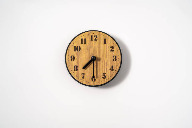 istock wood office wall clock with white dial on white background. wall clock on white background, top view. 1291403806