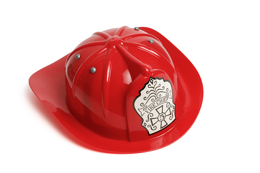 Red plastic children's fire chief helmet costume isolated on a white background