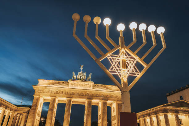 símbolo de menorah iluminado frente a la puerta de brandenburgo en berlín contra el cielo de la hora azul - brandenburg gate berlin germany germany night fotografías e imágenes de stock