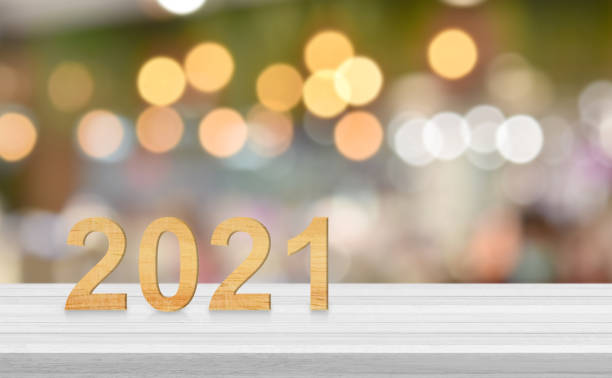 istock Wooden number on white wood table over blur bokeh light background, copy space for text 1291413346